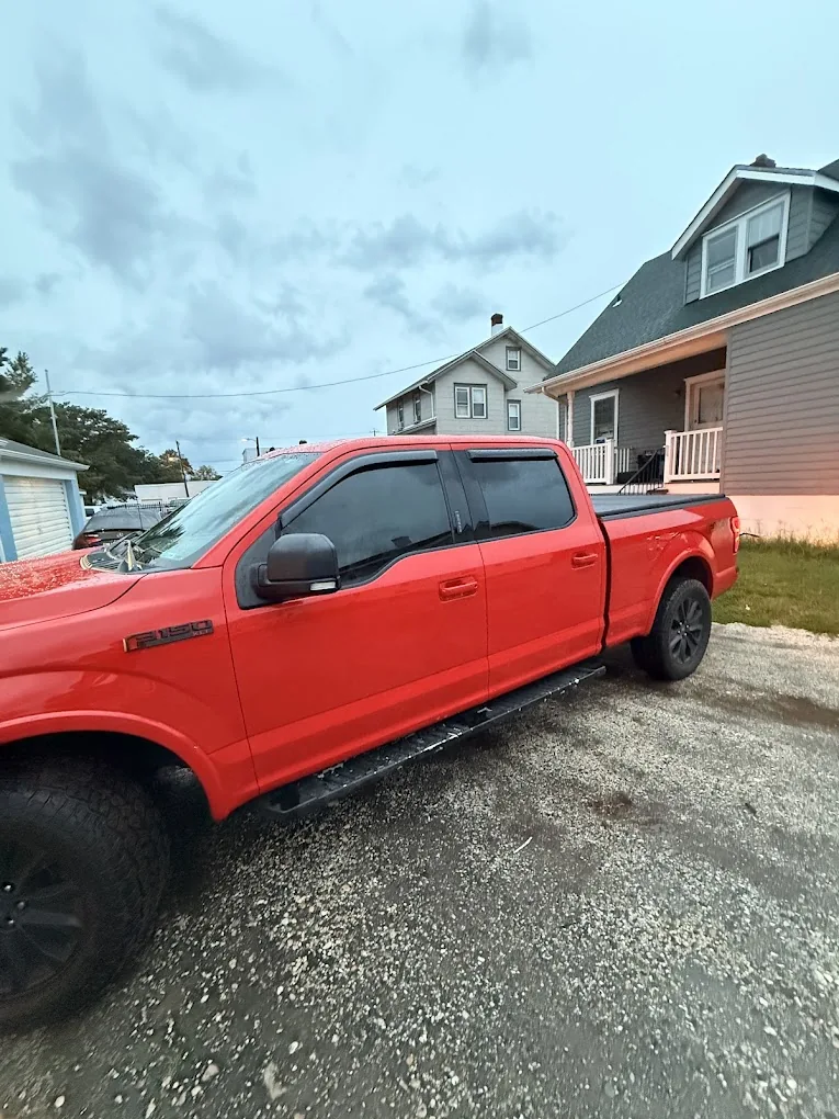 Red pickup truck photographed outside the shop